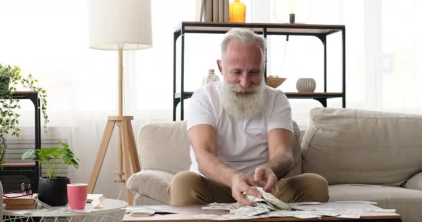 Hombre mayor emocionado por la enorme colección de billetes de dólar americano — Vídeo de stock