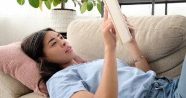 Evde kitap okuyan bir kadın. 