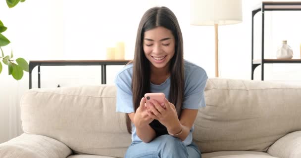 Mujer feliz usando el teléfono móvil en casa — Vídeos de Stock