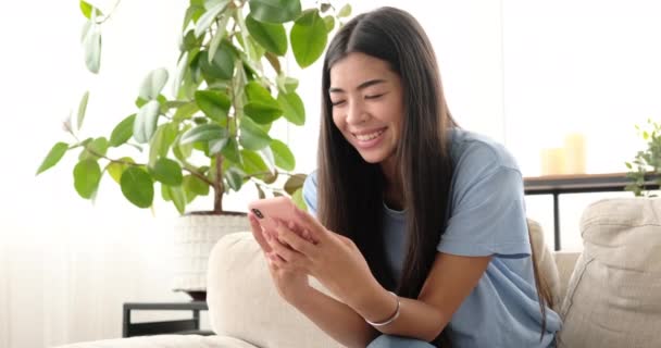 Vrouw chatten met behulp van mobiele telefoon thuis — Stockvideo