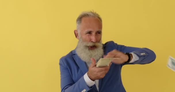 Старий бізнесмен кидає доларові купюри в повітря — стокове відео