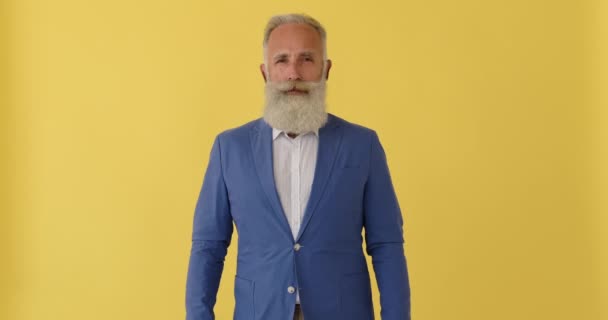 Sarı arka planda yakışıklı kıdemli iş adamı — Stok video