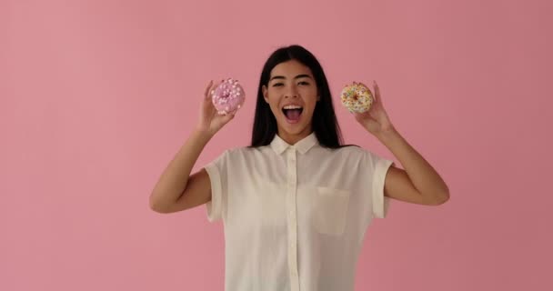 Bezaubernde Frau mit glasierten Donuts — Stockvideo