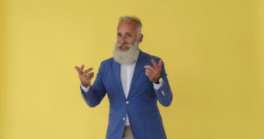 Heyecanlı erkek vlogcu sarı arka planda konuşuyor