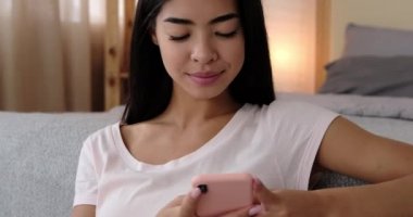 Evde cep telefonu kullanan mutlu kadın.