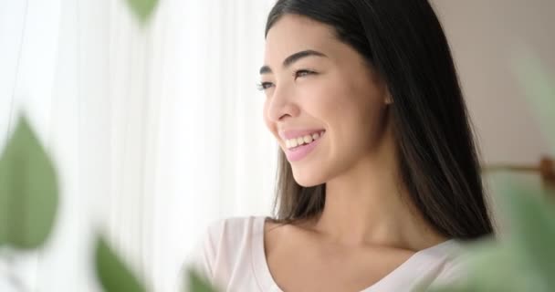 Lycklig kvinna tittar ut genom fönstret — Stockvideo