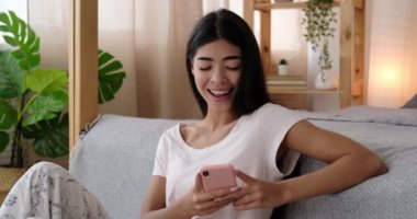 Evde cep telefonu kullanan mutlu kadın.