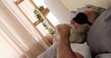 Adam uyanıyor ve yatakta geriniyor.