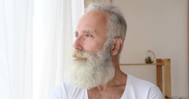 Pencereden bakan kıdemli bir adam.