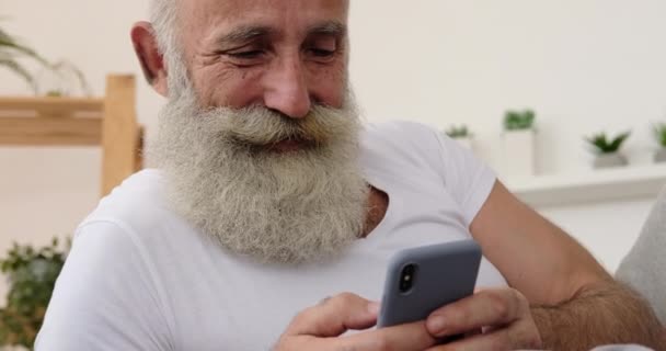 Viejo usando el teléfono móvil en casa — Vídeos de Stock