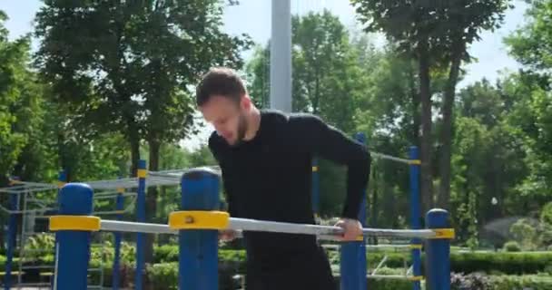 运动员在公园的双杠上做三头肌探头 — 图库视频影像