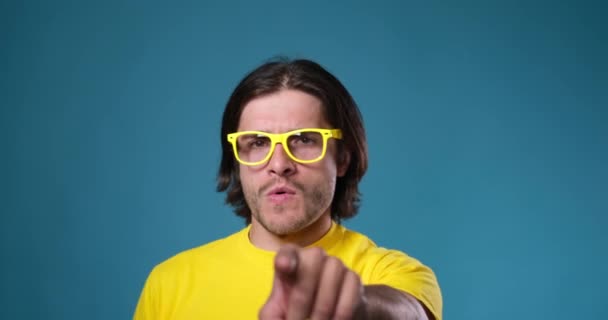 Homme aux lunettes jaunes dansant sur fond bleu — Video