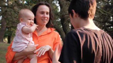 Bir anne, küçük kızıyla birlikte oynarken bir orman parkında ağaçların arasında sohbet ederken kucağına alır..