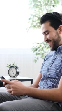 Yetişkin bir adam evdeki kanepeye yaslanır, gözleri kapalı ve gülümserken kulaklıkla kulaklıkla müzik dinler, yavaş çekimde yakalanır..