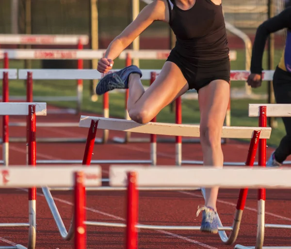 High School Girls Hits Her Knee Hurdle While She Running — Stock Photo, Image