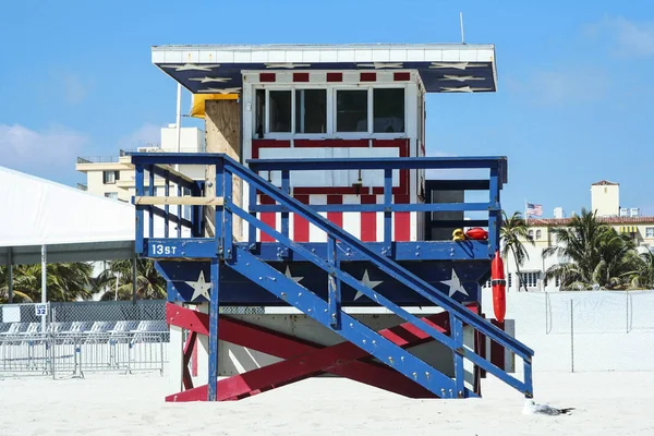 A red, white and blue lifeguard stand in miami beach.