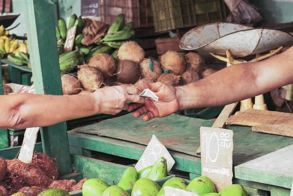 Money changing hands for produce purchased at a market in Havana Cuba.