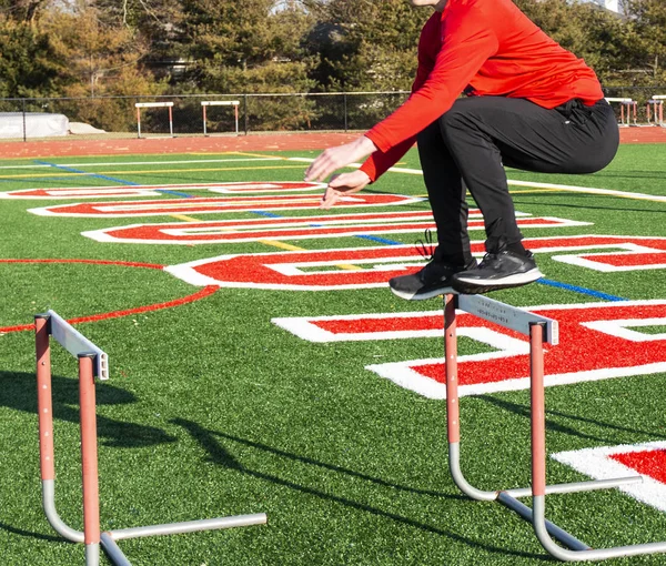 High School Track Field Athlete Jumping Hurdles Green Red Turf — Stock Photo, Image