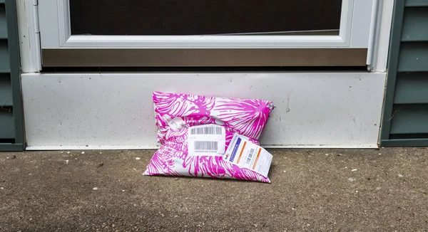 Babylon, Ny, Amerika Birleşik Devletleri - 5 Ekim 2018: pembe ve beyaz paket için olası hırsızlık maruz ön kapıda bıraktım bir plastik.