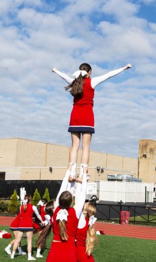 Üç kız havada başlarının üzerinde yukarıya onların takım Dengeleme ile rutin beore eve dönmek Lise amigo pratik.