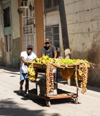 Havana, Küba'da - 25 Temmuz 2018: iki adam sıkıştırıyorlar Havana Küba'da yolun bir sepeti meyve Satıyoruz.