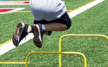 Genç bir atlet atletizm uygulama, vücut geliştirme yüksek sarı mini Engelli bir yeşil çim sahada efendim iki ayak üzerinde bulunuyor.
