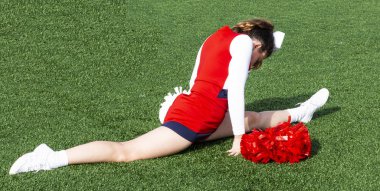 Kırmızı, beyaz ve mavi kıyafet yeşil çim alan weaing üzerinde bir bölünme, bir lise amigo kız.