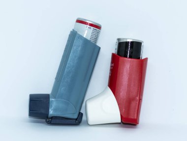 Bir mavi ve kırmızı athma bir inhaler ayakta beyaz bir arka plan ile kurtarma.