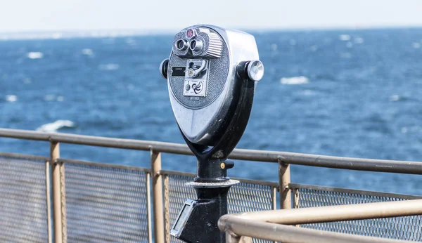 A coin operated telescope in available to look out on to the rough waters on a ferry boat in the Long Island Sound.