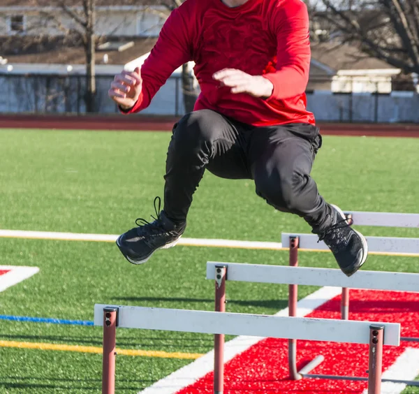 Löpare hoppa över hindren för strngth och agility praxis — Stockfoto