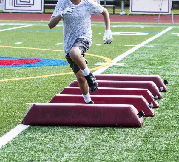 Young football player avoiding red barrier at practice — Stock Photo, Image