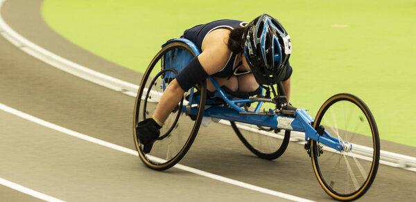Wheelchair athlete racing the mile indoors