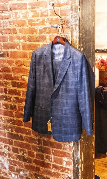 Blue suit hanging on a brick wall