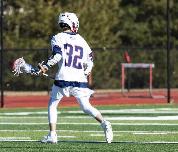 High school lacrosse player running with the ball