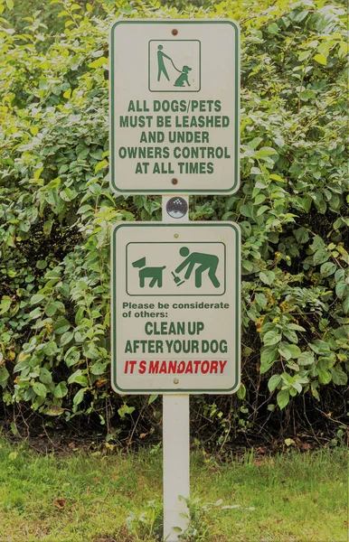 Two signs reminding pet owners to have a leash and clean up