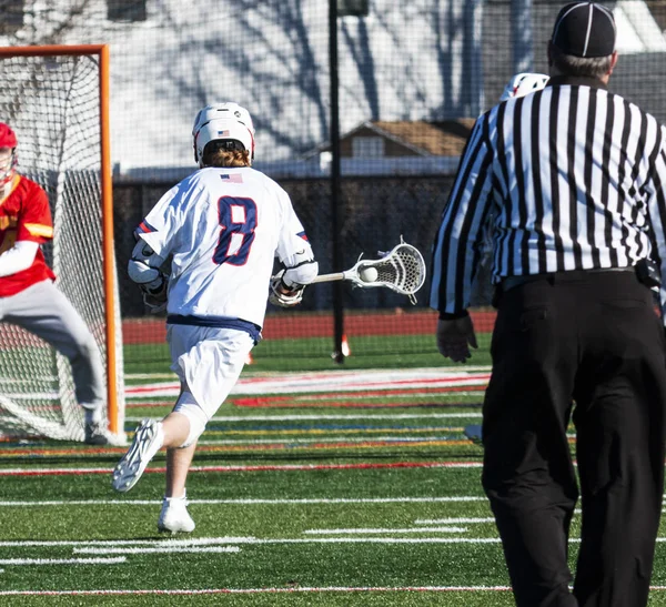 Lacrosse athlete running down field toward the golie with ball