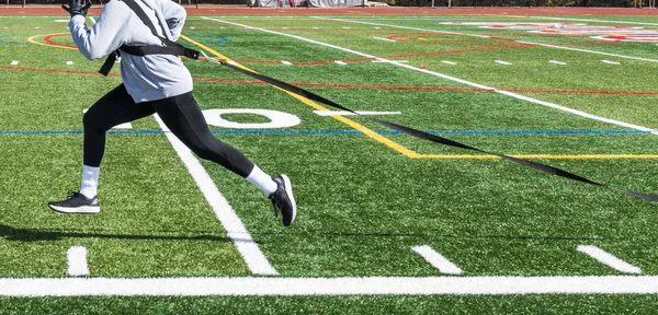 Vista lateral do atleta puxando trenó com peso em todo o campo — Fotografia de Stock