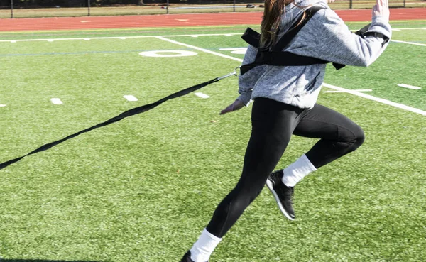 Adolescente do sexo feminino puxando um trenó ponderado na prática — Fotografia de Stock