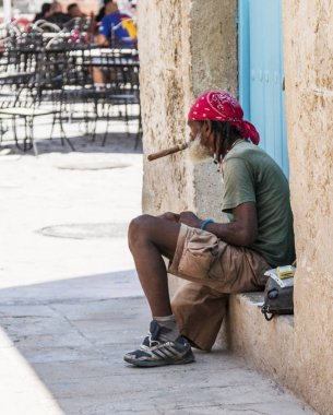 Kübalı adam büyük puro sigara verandada oturan