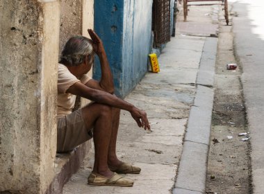 Kübalı adam Havana C evinin kapısında oturan ve sigara