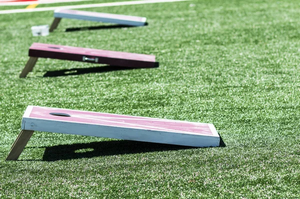 Çim alanında üç ev yapımı cornhole oyunları