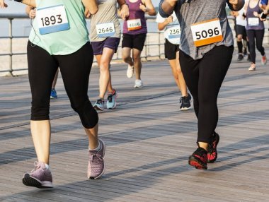 Koşucular belden aşağıbir boardwalk üzerinde yarış