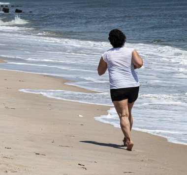 Okyanus yanında kum üzerinde jogging kadınlar