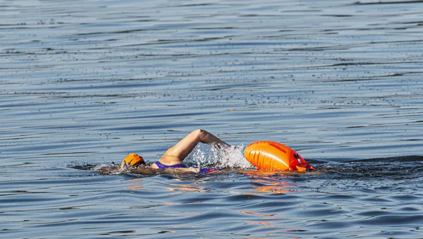 Výcvik plavících se v modré vodě o samotě s oranžovou bójí — Stock fotografie