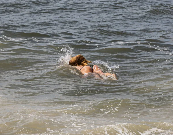 Ruiva yound senhora como ela entra na água por trás — Fotografia de Stock