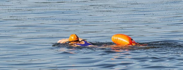 Samice plavání v otevřené vodě sama o sobě oranžová bóje pro bezpečný — Stock fotografie
