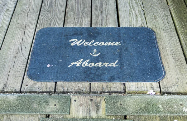 Welcome aboard mat at entrance of a boardwalk