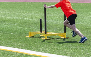 Genç çocuk çim alanında kızak iterek