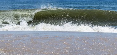 Kıyıya inerken okyanus dalgası kıvrılıyor