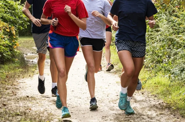 Vista frontal de um grupo de corredores treinando em um caminho de sujeira no — Fotografia de Stock